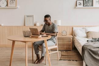 Uomo lavora al computer a casa sua